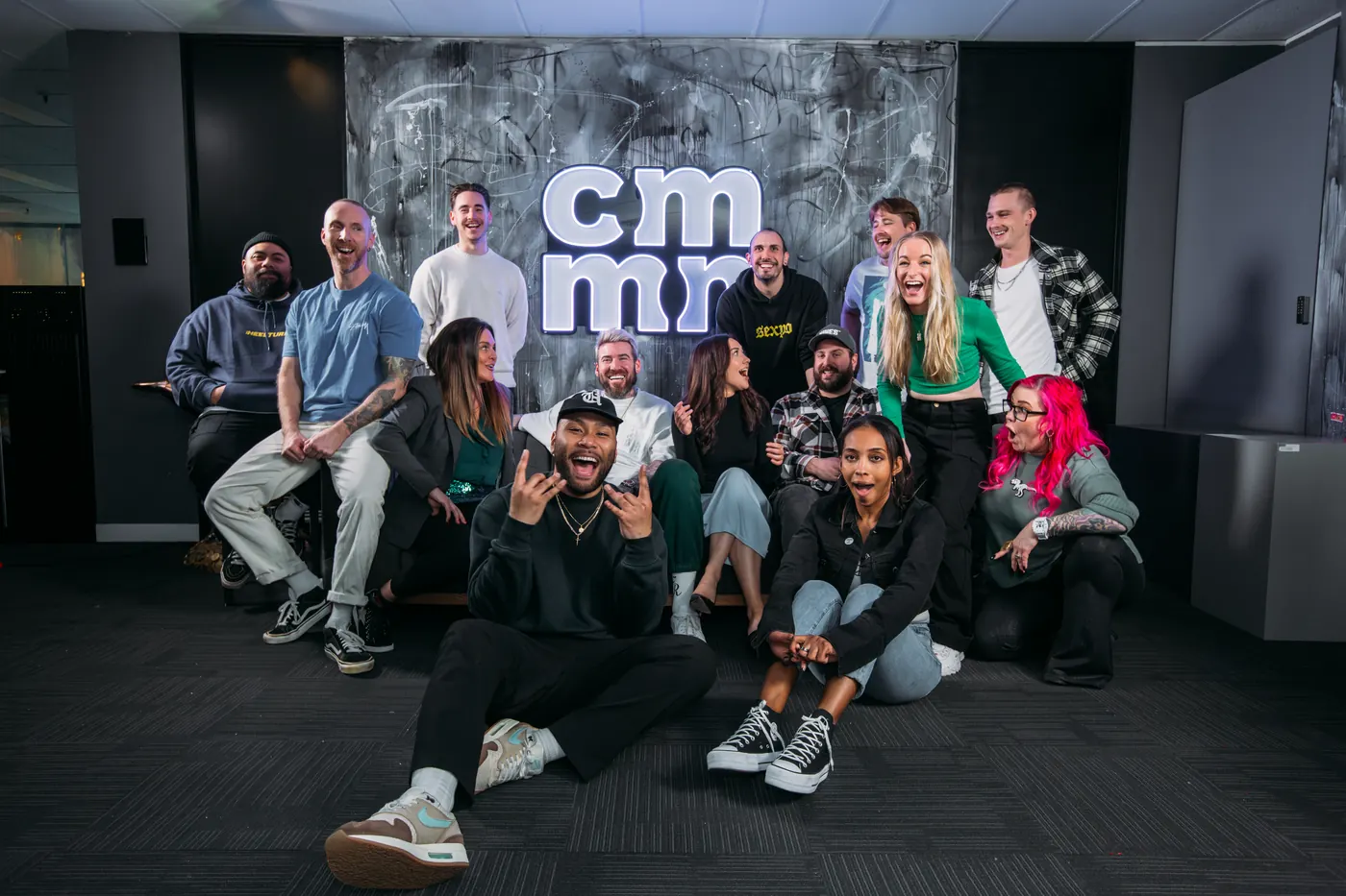 The event team gathered in front of the CMMN wall