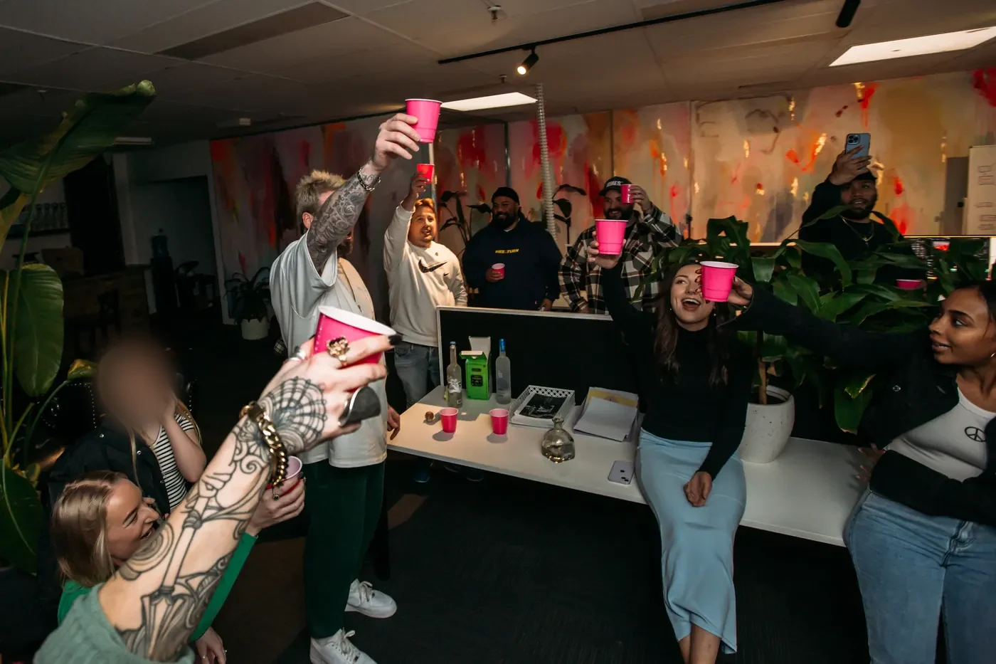 The team raising cups in the office